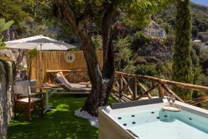 a garden with a table and an umbrella and a tree at Villa Nannina in Positano