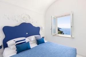 a blue and white bedroom with a bed and a window at Villa Nannina in Positano