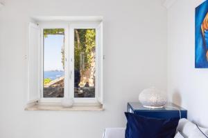 a living room with a window with a view of the ocean at Villa Nannina in Positano