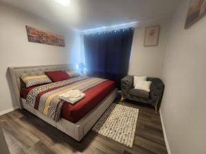 a bedroom with a bed and a chair at Cozy one bedroom in Airdrie in Airdrie