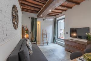 a living room with a couch and a tv at Terracielo Isola, tra Parco e Centro Firenze x 5 con giardino in Florence