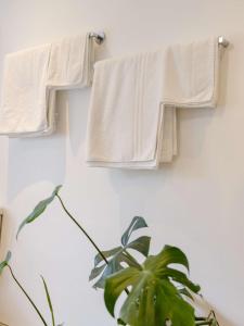 two white towels hanging on a wall with a plant at Weavers Retreat by Weavers of Haworth in Haworth +12 photos