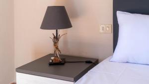 a lamp on a table next to a bed at Casa Stella Di Mare in Schifoni +23 photos
