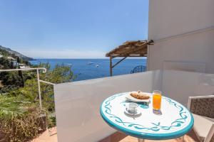 a table with a plate of food on a balcony with the ocean at Villa Nannina in Positano