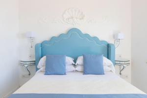 a blue bed with white sheets and blue pillows at Villa Nannina in Positano