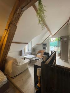 an attic bedroom with a bed and a living room at Maison bleue in Beynes