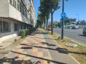a sidewalk next to a street with a building at La Constanta Gara in Constanţa