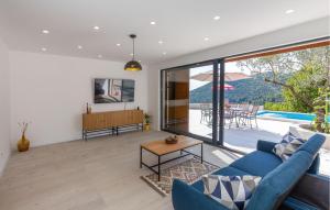 Una sala de estar con un sofá azul y una mesa. en Gorgeous Home In Ploce, en Ploče