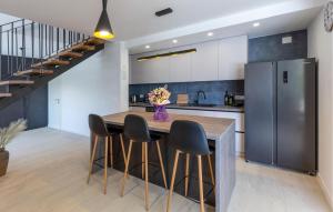 Una cocina con una mesa con sillas y un refrigerador. en Gorgeous Home In Ploce, en Ploče
