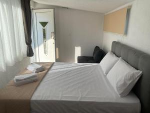 a bedroom with a large white bed and a window at STUDIOS TASOS BI in Chrysi Ammoudia