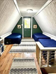 ein Zimmer mit zwei blauen Betten und einer grünen Tür in der Unterkunft HOT TUB -Secluded Cabin Cave Run Lake and near Red River Gorge in Wellington