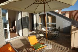 a patio with a table and chairs and an umbrella at Sinfonia Martini in Verbania +12 photos
