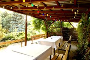 two tables and benches under a pergola with lights at Biwak Bajlando in Wrocław