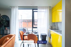 a kitchen with yellow cabinets and a table and chairs at Exquisite Central Suites Sheffield in Sheffield