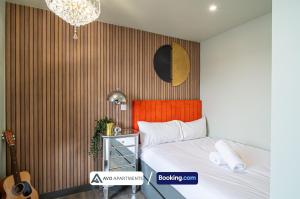 a bedroom with a bed with an orange headboard and a no appointment sign at Exquisite Central Suites Sheffield in Sheffield