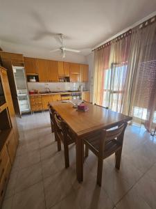 a kitchen with a wooden table and some chairs at Casa Yuliya in Letojanni