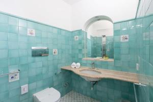 a blue tiled bathroom with a sink and a toilet at Villa Nannina in Positano