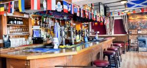 a bar with lots of bottles of alcohol and bar stools at The Prince Albert, Whitton in Whitton