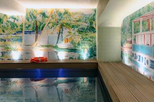 a swimming pool in a room with a tropical mural at Drawing House in Paris