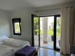 ein Schlafzimmer mit einem Bett und einer Glasschiebetür in der Unterkunft Villa Beba - Apartments in Senj