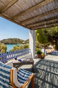 a wooden table and chairs on a patio with a view of the water at Nina's House above the amazing sea! in Samos +9 photos