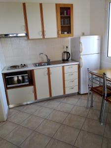 a kitchen with white cabinets and a white refrigerator at Emmanouil in Kythira