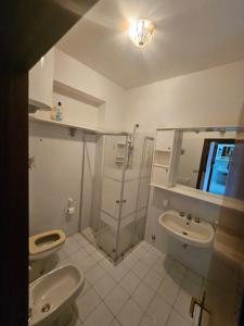 a bathroom with two toilets and a shower and a sink at Casa Yuliya in Letojanni