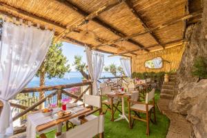a restaurant with tables and chairs and a view of the ocean at Villa Nannina in Positano