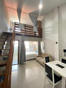 a room with a loft bed and a living room at Boutique FLAT 1 min da Praia in Luis Correia
