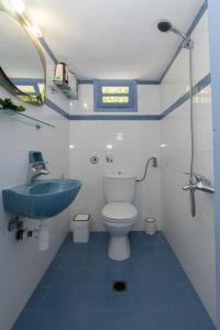 a small bathroom with a sink and a toilet at Nina's House above the amazing sea! in Samos
