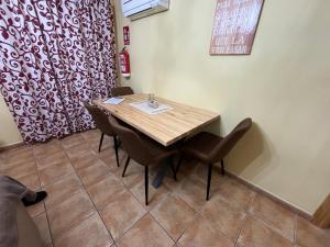 Un comedor con mesa y sillas de madera. en Apartamento El Río 3, en Arroyo Frío