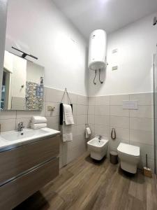 een witte badkamer met een wastafel en een toilet bij Casa Marì Holiday House in Palermo +19 foto's