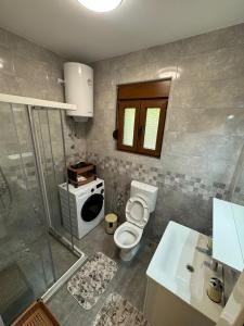 ein Badezimmer mit Toilette, Waschbecken und Mikrowelle in der Unterkunft Apartment Vento di Bocche III in Kotor + 8 Fotos