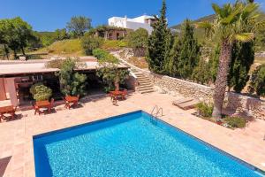 a swimming pool in front of a villa at Hotel Rural Can Pujolet in Santa Agnès de Corona