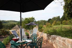 une table et des chaises avec un parasol sur une terrasse dans l'établissement Cathedral View - Romantic Wye Valley Country House 1 Bed Apartment - Dog Friendly, à Coleford 14 autres photos
