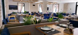 a restaurant with wooden tables and blue chairs at Lumi i Bardhe Hotel & Restaurant in Kuç