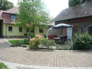 a house with a table and an umbrella in the yard at Landurlaub in Schiebsdorf in Kasel-Golzig