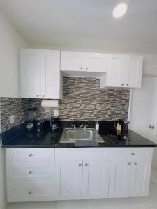 a kitchen with white cabinets and a sink at New Mid Miami Beach apt free parking and beach access in Miami Beach
