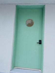 a green door with a window in a building at New Mid Miami Beach apt free parking and beach access in Miami Beach