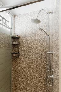 une douche avec une porte vitrée dans une salle de bain dans l'établissement Sunny apartment in the Center, 5 min. from the Beach, à Fuengirola