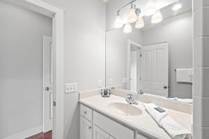 a white bathroom with a sink and a mirror at La Valencia Villas in Rosemary Beach +47 photos