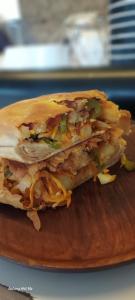 a sandwich sitting on top of a wooden cutting board at GUESTHOUSE MAC Terranova in Rwamagana