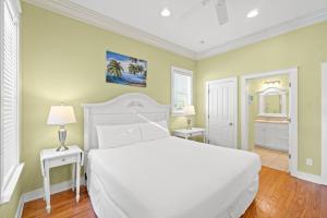 a bedroom with a white bed and two night stands at La Valencia Villas in Rosemary Beach