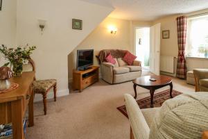 斯特拉斯佩弗Rose Cottage的客厅里有一张沙发和一台电视