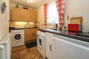 斯特拉斯佩弗Rose Cottage的厨房配有洗衣机、洗衣机和烘干机。 更多16张照片