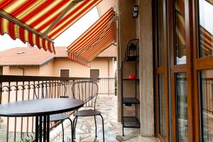 a patio with a table and chairs on a balcony at Appartamento Paprika 1966 una comfort zone in Savigliano