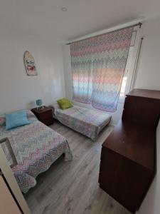 a small room with two beds and a window at Del Rodriguez in Cunit
