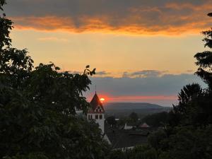 a sunset over a building with the sun in the sky at Wohnung mit schönem Aussicht in Bendorf