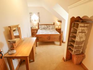 a bedroom with a bed and a desk and a shelf at Daisy Cottage in Lincoln