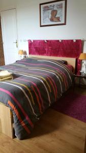 Una cama con una manta de colores encima. en Le Clos des Meix, en Lanthes